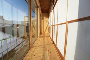 pasillo de un edificio con suelo de madera y paredes de cristal en RIKKA BABA ICHI en Takayama