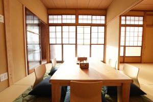 uma sala de jantar com uma mesa de madeira e cadeiras em RIKKA BABA ICHI em Takayama
