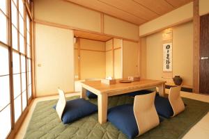 um quarto com uma mesa de madeira e cadeiras em RIKKA BABA ICHI em Takayama