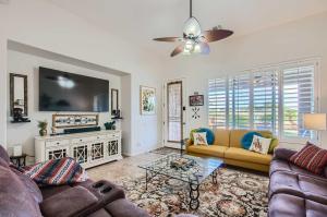 a living room with two couches and a flat screen tv at Phoenix Retreat with Heated Pool, Gas Grill and Yard! in Avondale