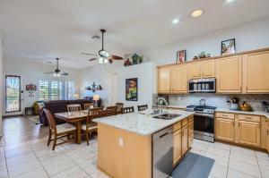 a kitchen and living room with a table and a dining room at Phoenix Retreat with Heated Pool, Gas Grill and Yard! in Avondale