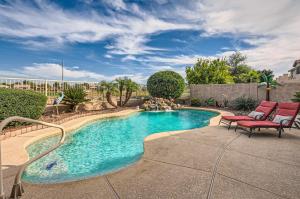 a swimming pool with two chairs and a fountain at Phoenix Retreat with Heated Pool, Gas Grill and Yard! in Avondale