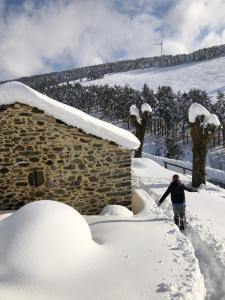 提內奧的住宿－Ca Manín，一个人在建筑物旁的雪中行走
