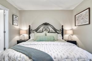 a white bedroom with a large bed with two lamps at Luxury Condo, Sleeps 6, 3.2 Miles to Dollywood in Pigeon Forge +25 photos