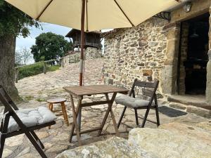 提內奧的住宿－Ca Manín，一张带两把椅子的木桌和一把伞
