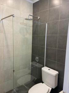 Un baño con inodoro y ducha de cristal. en Deptos John Vargas, en Guaymallén 10 fotos más
