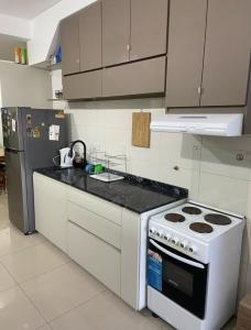 una cocina con estufa y refrigerador en Deptos John Vargas, en Guaymallén
