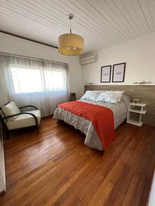 a bedroom with a bed with a red blanket at Mendoza908 in Nueve de Julio