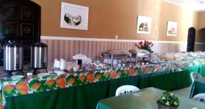 a long table with a green table cloth and some food at Pousada Praia Dos Coqueiros in Conde