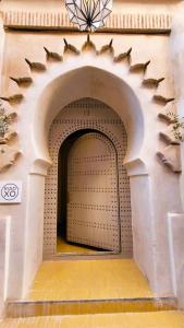 une arche dans un bâtiment avec une porte dans l'établissement Riad XO, à Marrakech