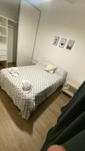 a bedroom with a bed with a comforter on it at Departamento 2 hab con patio y parrilla in Rosario