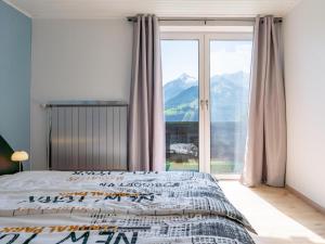 a bedroom with a bed and a large window at Jeremys in Piesendorf