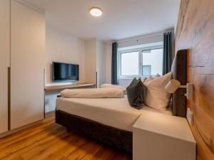 Habitación de hotel con cama y TV en Ferienwohnung Emilia, en Niedernsill