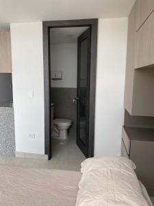 ein Schlafzimmer mit einem Bett und ein Badezimmer mit einem WC in der Unterkunft Excelente nuevo Apartaestudio in Popayan