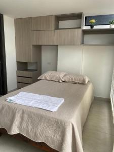 Un dormitorio con una cama con una sábana blanca. en Excelente nuevo Apartaestudio, en Popayán