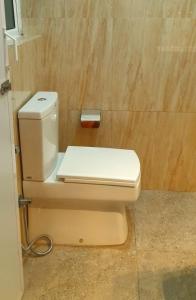een wit toilet in een badkamer met een houten muur bij Regent Residencies - Colombo in Colombo