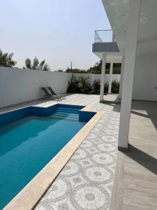a swimming pool on the side of a house at Villa Nohady : luxe, confort, moderne à Saly in Sali Tapé