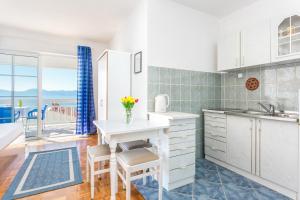 a kitchen with a table and chairs with a view of the ocean at Studio Podaca 6736b in Podaca