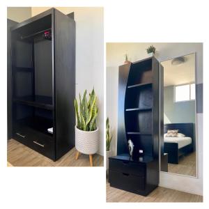 a black cabinet with a mirror and a plant at Departamento Raya in Puerto Ayora