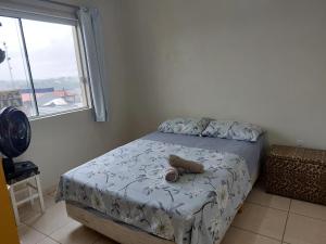 Un dormitorio con una cama con un osito de peluche. en Apto de 2 quartos com AR localizado no centro sul, en Santo Ângelo