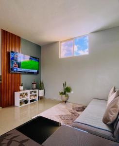 Departamento Raya في بويرتو أيورا: غرفة معيشة مع سرير وتلفزيون بشاشة مسطحة