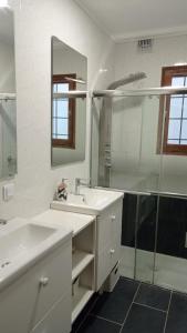 La salle de bains blanche est pourvue d'un lavabo et d'une douche. dans l'établissement Villa Niçoise.3P. 5 min de la plage, à Nice