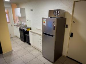 uma cozinha com um frigorífico e uma caixa em cima em Departamento céntrico con estacionamiento em Concepción