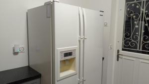 a white refrigerator freezer sitting in a kitchen at Villa Niçoise.3P. 5 min de la plage in Nice