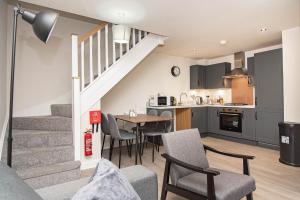 een keuken en een woonkamer met een tafel en stoelen bij Solid Mirror Modern Riverside Home, Doncaster in Doncaster