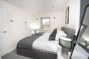 a bedroom with a bed and a window at Solid Mirror Modern Riverside Home, Doncaster in Doncaster