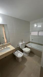 a bathroom with a toilet and a sink and a bath tub at Luminoso departamento con cochera en San Isidro in San Isidro