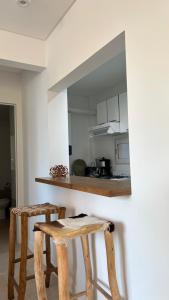 a kitchen with two wooden stools in front of a counter at Luminoso departamento con cochera en San Isidro in San Isidro