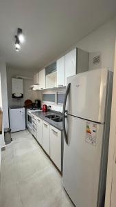 a kitchen with white cabinets and a refrigerator at Luminoso departamento con cochera en San Isidro in San Isidro