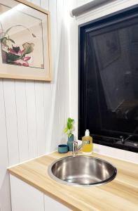 a silver sink in a kitchen with a window at Tiny Retreat Noosa in Cooroibah