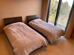 Postel nebo postele na pokoji v ubytování 富士山一望楽楽草
