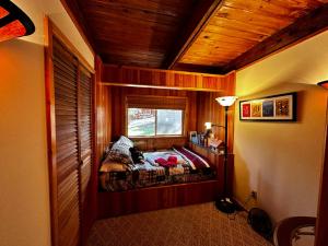 1 dormitorio con 1 cama en una habitación con ventana en Well-appointed ADK cabin directly on 106’ water!, 