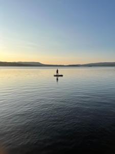 una persona sentada en un barco en medio de un lago en Well-appointed ADK cabin directly on 106’ water!, 