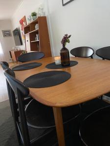 a wooden table with chairs and a vase with flowers on it at Balcombe Retreat in Mount Martha