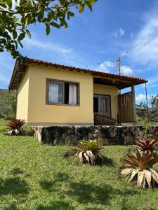 ein Haus mit einer Steinmauer davor in der Unterkunft Pousada Sete Quedas in Carrancas
