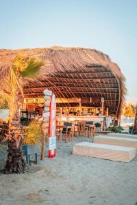 un restaurante con techo de paja en la playa en ABBY TOURISM, en Playa Blanca