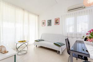 a white living room with a chair and a table at Apartments by the sea Cove Gornja Krusica, Solta - 20021 in Stomorska