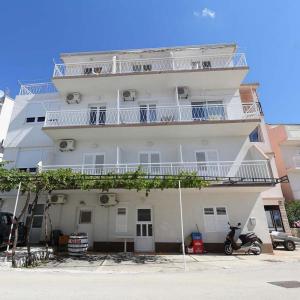 ein weißes Gebäude mit Balkon und einem Roller davor in der Unterkunft Apartments with a parking space Zivogosce - Blato, Makarska - 22253 in Podgora