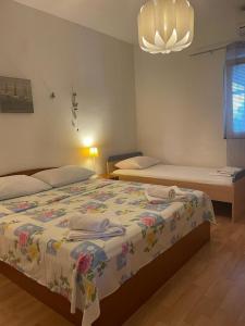 1 Schlafzimmer mit 2 Betten und einem Kronleuchter in der Unterkunft Apartments with a parking space Zivogosce - Blato, Makarska - 22253 in Podgora