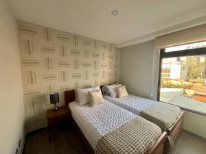 sypialnia z 2 łóżkami i oknem w obiekcie Minimalist 3 Bedroom Apartment w mieście Gwatemala