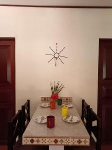a dining room table with a clock on the wall at Casa Amapola in La Cruz