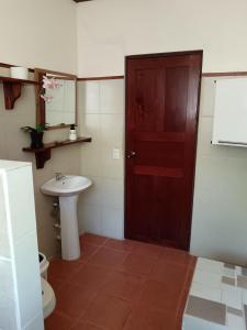 a bathroom with a toilet and a sink and a door at Casa Amapola in La Cruz