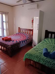 1 dormitorio con 2 camas y nevera en Casa Amapola, en La Cruz