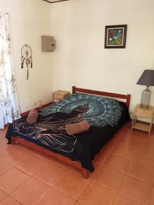 a bedroom with a bed with a black and white blanket at Casa Amapola in La Cruz