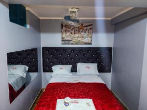Habitación pequeña con cama con manta roja en Hostal Paris, en Lima