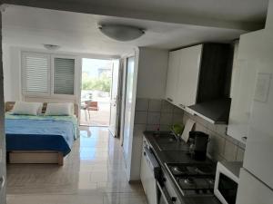 a small kitchen with a bed and a stove at Apartments with a parking space Vinjerac, Zadar - 22585 in Posedarje